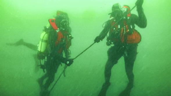 © MN - C’est avec une autonomie de 20 minutes et plusieurs dizaines de kilos de matériel sur les épaules que les marins plongent pour rejoindre l’épave par 26 m de fond. La descente doit être rapide afin de dédier un maximum du temps de plongée au travail sur le fond.