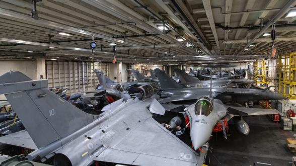 © L.Bernardin/MN - Au rythme de l’activité opérationnelle, les opérateurs de manutention déplacent les Rafale Marine du pont d’envol au hangar et inversement. Pour cela, ils disposent de deux ascenseurs. Dans le hangar, le moindre mètre carré est utilisé pour optimiser le rangement des avions de chasse embarqués.