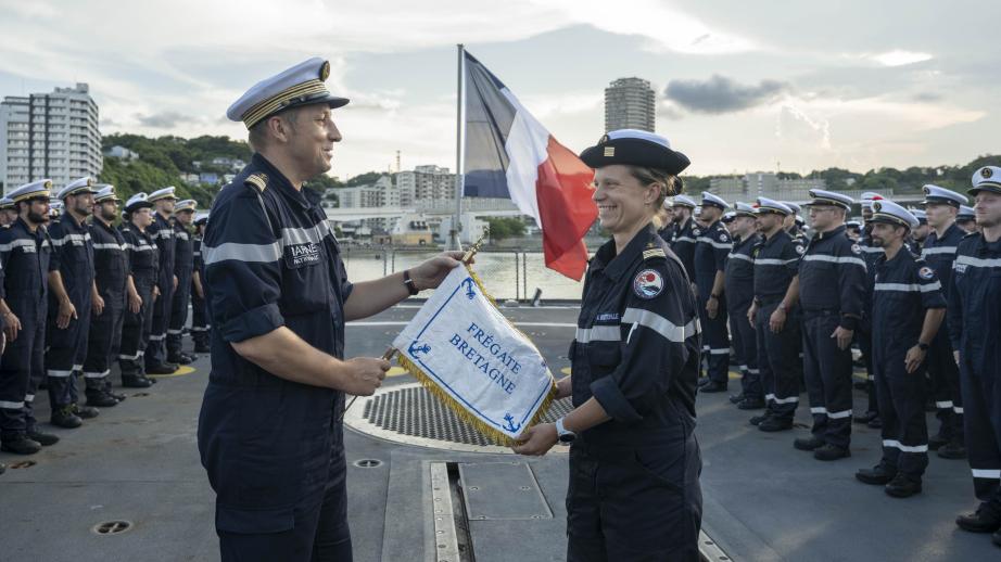 Le commandant quittant remet au commandant prenant le fanion de l'équipage