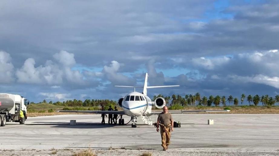 Une personne en tenue de vol marche sur un tarmac