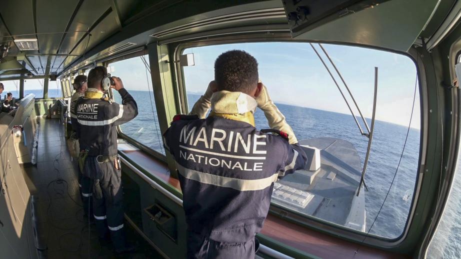 Un groupe de marin observe l'horizon à la jummelle