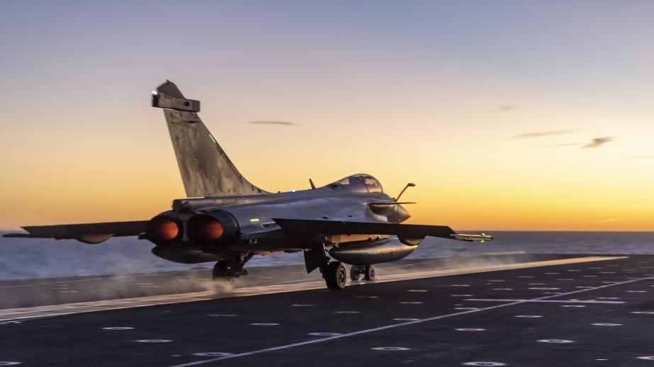 Un Rafale Marine au coucher de soleil sur le pont d'envol