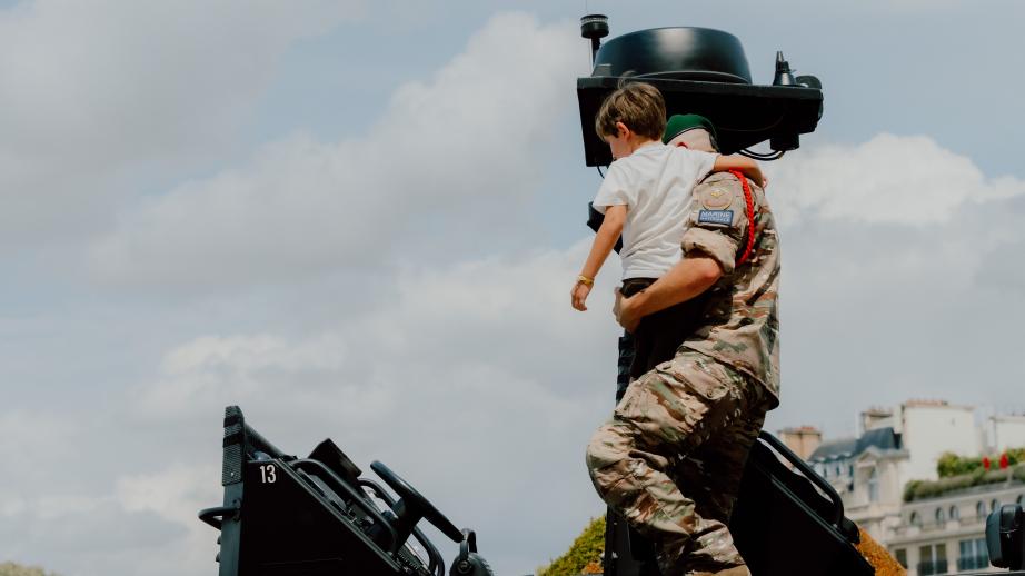 Un commando porte un enfant pour le poser sur une vedette de la Marine. 