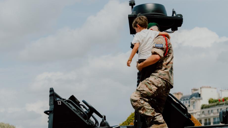Un commando porte un enfant pour le poser sur une vedette de la Marine.
