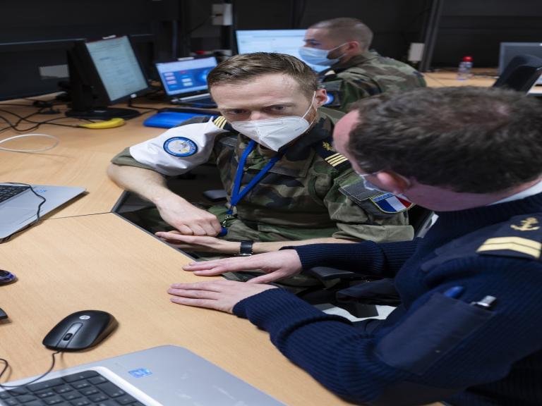 Un marin et un officier de l'armée de l'air discutent. Ils sont au centre national d'études spatiales (CNES) pendant l'exercice militaire spacial AsterX 2021.