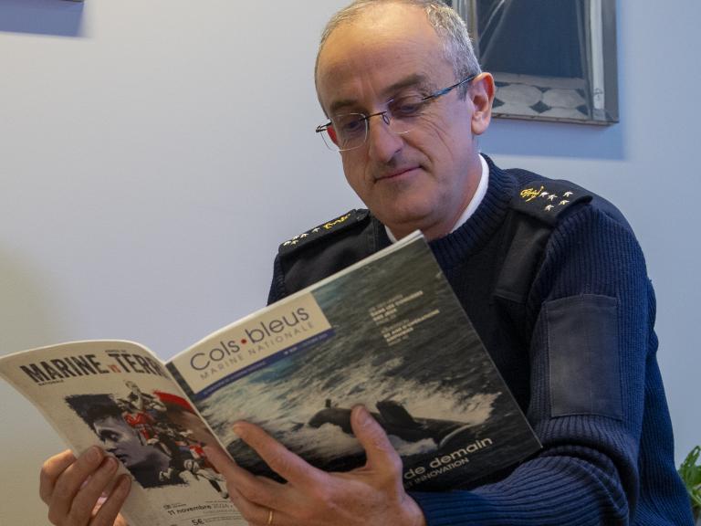 Un amiral en train de lire un magazine